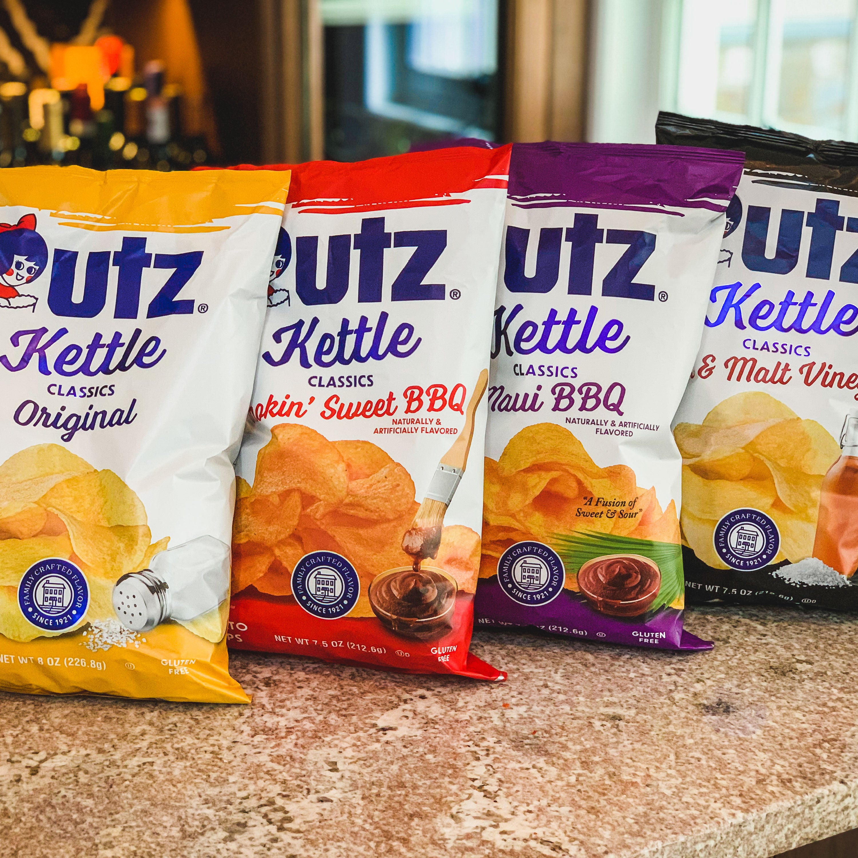 Four Utz Kettle Classics potato chip bags on a countertop.
